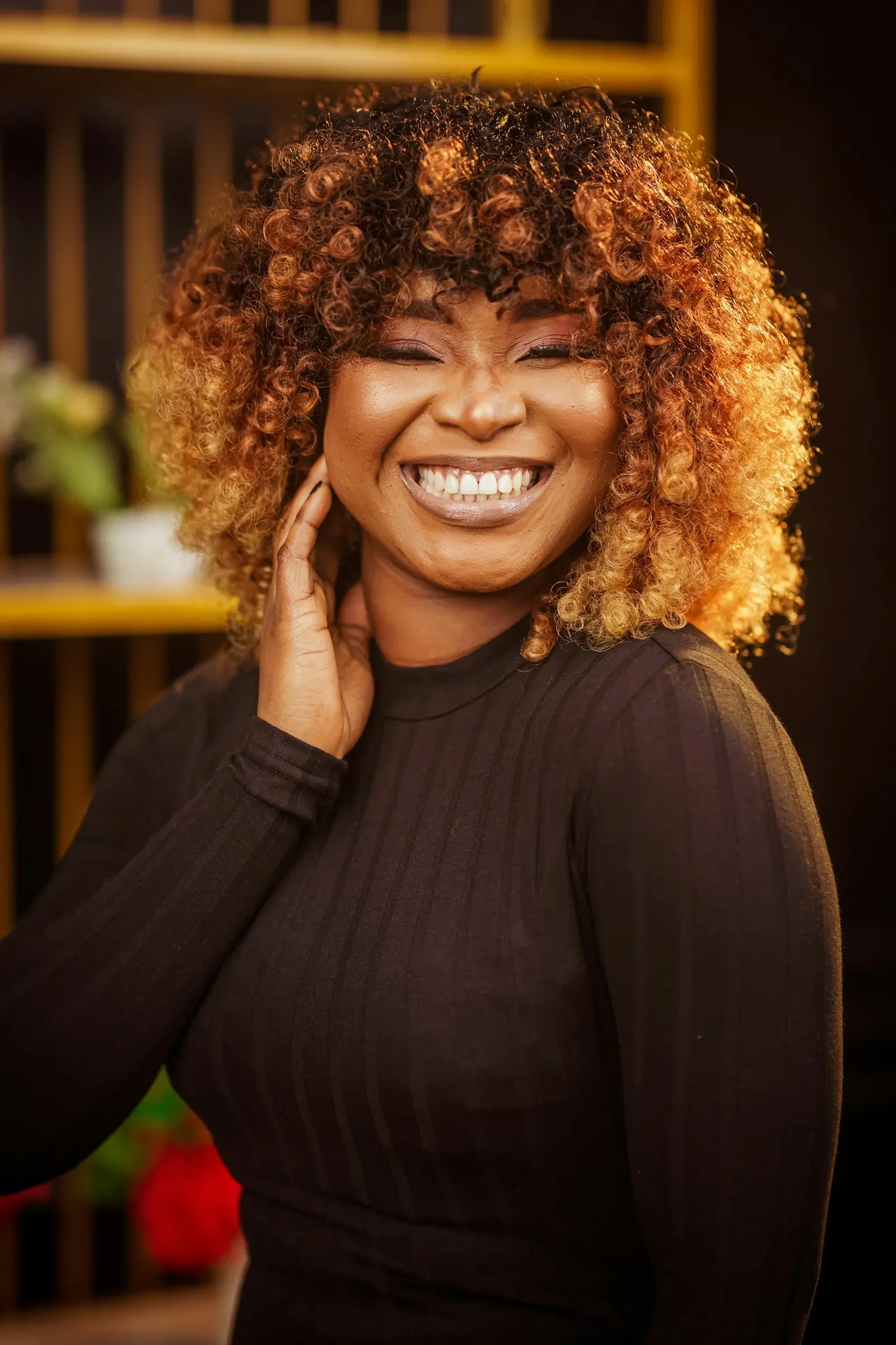 Femme souriante avec une coiffure bouclée lumineuse